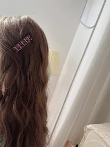 Vue rapprochée détaillée d'une pince à cheveux brillante avec strass sur de longs cheveux.