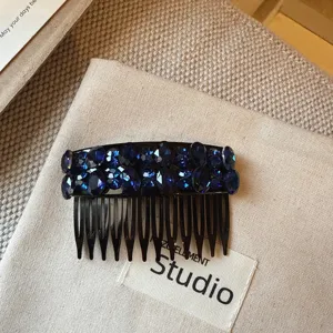 Gros plan d'un peigne à cheveux scintillant en strass bleu foncé, élégant accessoire de coiffure.