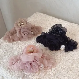 Close-up detail of organza flower hair claws with pearl accents, elegant hair styling accessory.