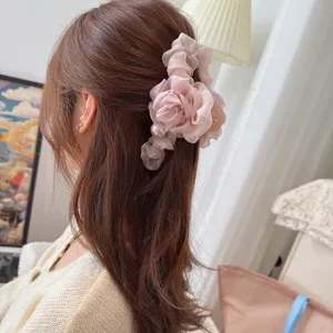 Detailed view of pink chiffon flower hair claw clip with pearl accent for elegant hairstyles.