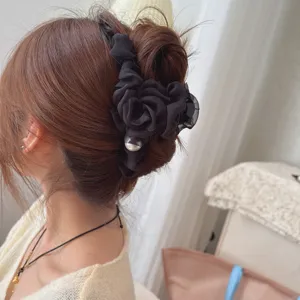 Black mesh flower hair claw clip detail shot, elegant fabric rose design with pearl decor.