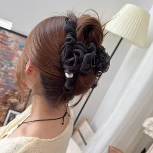Detailed view of a black mesh flower hair claw clip with pearl, elegant hair styling accessory.