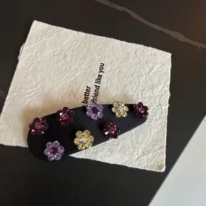Rhinestone flower hair clip detail shot, elegant black fabric snap clip with sparkling crystals.