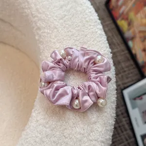 Pink satin pearl hair scrunchie, pleated fabric hair tie for cute ponytail and bun styling.