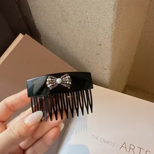 Elegant black acrylic hair comb featuring a sparkling rhinestone and pearl bow design for women.