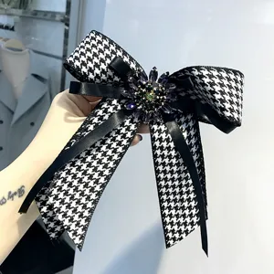 Spilla da colletto con fiocco pied-de-poule e cristalli scintillanti, elegante stile college.
