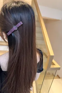 Detailed shot of a chic purple fabric hair clip featuring sparkling rhinestone ring accent.