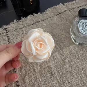 Fabric camellia flower brooch detail, elegant white floral accessory for suit lapels.