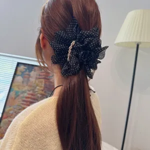 Close-up detail of a French vintage black polka dot mesh hair claw clip featuring delicate pearls.