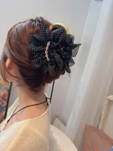 Detail view of a French vintage polka dot mesh hair claw clip with elegant pearl decoration.