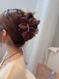 Brown polka dot mesh hair claw clip detail, elegant hair accessory for women styling.