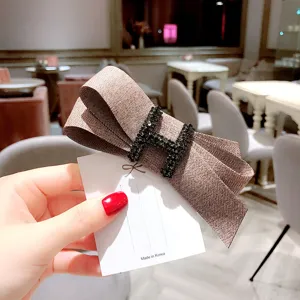 Brown herringbone fabric bow hair clip with black rhinestone H letter design spring clip