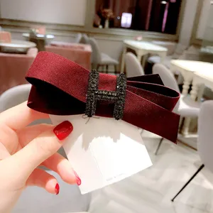Burgundy fabric bow hair clip with rhinestone H buckle, elegant spring clip for women ponytail.