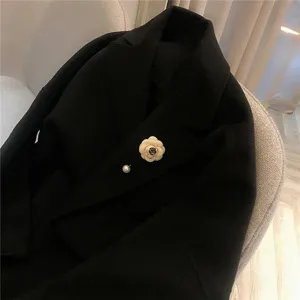 Elegante spilla con fiore di camelia e perla per cappotto da donna, accessorio chic.