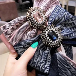Gros plan detail de broche double noeud papillon vintage strass gemme, accessoire de tissu
