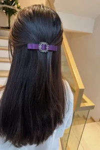 Purple satin bow hair clip with sparkling crystal rhinestone square buckle for women detail view.