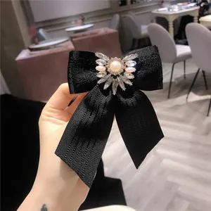 Dettaglio spilla fiocco in cristallo nero, elegante spilla da colletto in nastro di stoffa da donna.