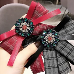Détail de broche nœud à carreaux avec centre en strass scintillants et rubans en tissu.