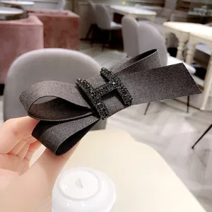 Elegant fabric bow hair clip with rhinestone H detail, stylish spring barrette for women.