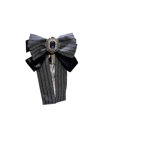 Broche nœud papillon rayée vintage avec pierre précieuse, détail accessoire exquis.