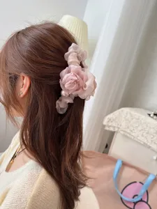 Detail view of a pink mesh flower hair claw clip with pearl decoration, perfect for styling.