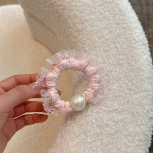 Pink mesh lace scrunchie detail view, elegant hair tie with pearl accent for chic hairstyles.