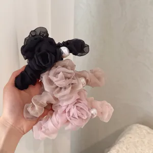 Detail shot of elegant mesh flower hair claw clip with faux pearl, stylish hair accessory.