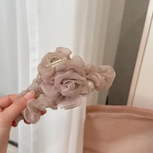 Mesh flower hair claw clip with pearl, pleated fabric design for elegant bun styling.