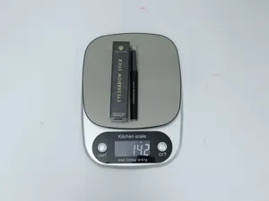 Detail view of Young Vision eyeshadow stick with box on scale, showing net weight and quality.