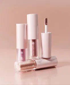 Close-up detail of shimmering liquid eyeshadow with applicator brush, metallic finish.