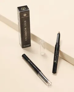 Detailed view of the dual black eyeshadow sticks with transparent caps and branded box.