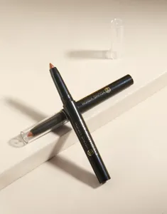 Detail shot of two pearl shimmer eyeshadow sticks in black casing displayed neatly on stand.