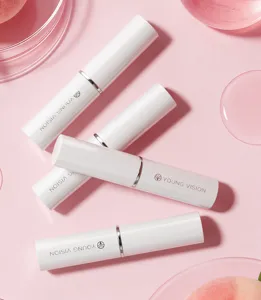 YOUNG VISION white tube lip balm set detail view, pink background with peach and care.