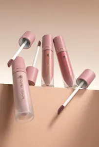 Primo piano dettagliato di rossetti liquidi effetto velluto opaco con applicatore neutro.