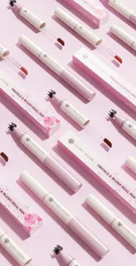 Detailed view of dual-ended liquid freckle and blush pens with matching pink packaging boxes.