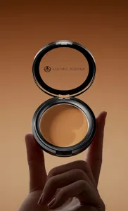 Close-up detail of the matte bronzer contour powder in a sleek black compact case for makeup.