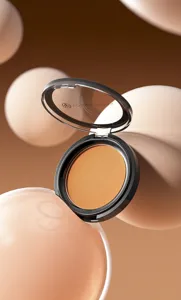 Detail view of matte bronzer contour powder compact with clear lid in aesthetic nude tone.