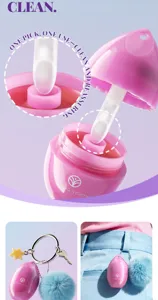 Pink egg-shaped lip balm detail view with applicator and fluffy ball keychain accessory