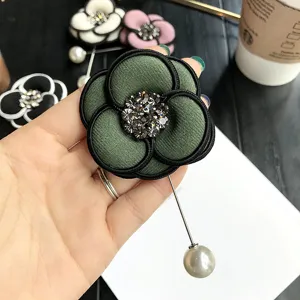 Exquisite rhinestone camellia flower brooch with pearl pin, elegant fabric accessory for women.
