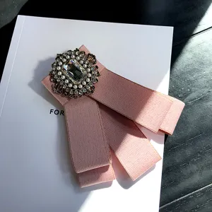 Retro court style pink bow brooch featuring crystal rhinestone and pearl accessories.