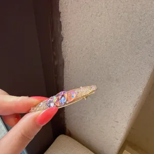 Primo piano sui dettagli della forcina per capelli con strass brillanti e colorati.
