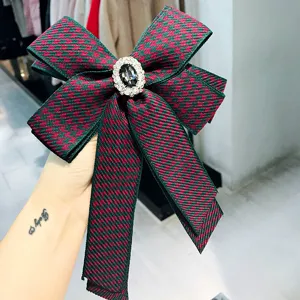 Detailed shot of houndstooth bow brooch with sparkling rhinestone center, crystal accent.