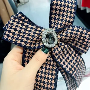Detail view of houndstooth bow brooch with crystal rhinestone cluster and pin fastening.