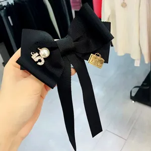Süße schwarze Schleifen-Brosche im College-Stil mit Perlen-Ziffer für Damen Mode.