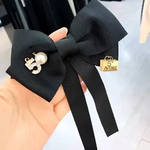 Elegante schwarze Schleifen-Brosche mit Perle und Nummernanhaenger, süßer College-Stil.
