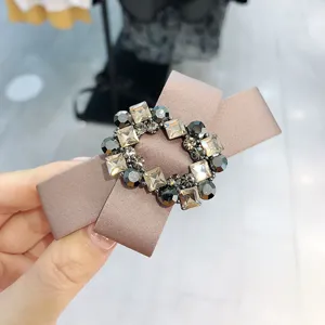 Elegant rhinestone bow hair clip with satin fabric cross design for women retro styling.