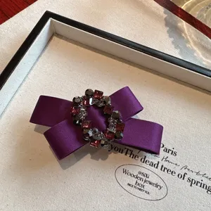 Purple satin bow hair clip with vintage crystal rhinestones, elegant dark hair accessory for women.