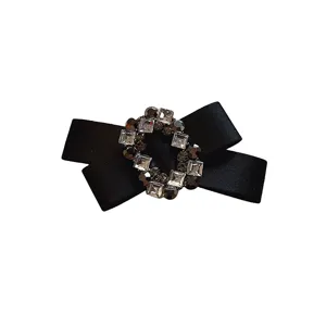 Black satin bow hair clip with sparkling rhinestone crystal center, elegant vintage retro hair accessory.