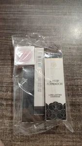 Close-up detail of Young Vision black series makeup foundation and liquid eyeshadow set in bag.