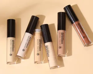 Λεπτομερής απεικόνιση σωληναρίων υγρού concealer σε nude φοντό μακράς διαρκείας.